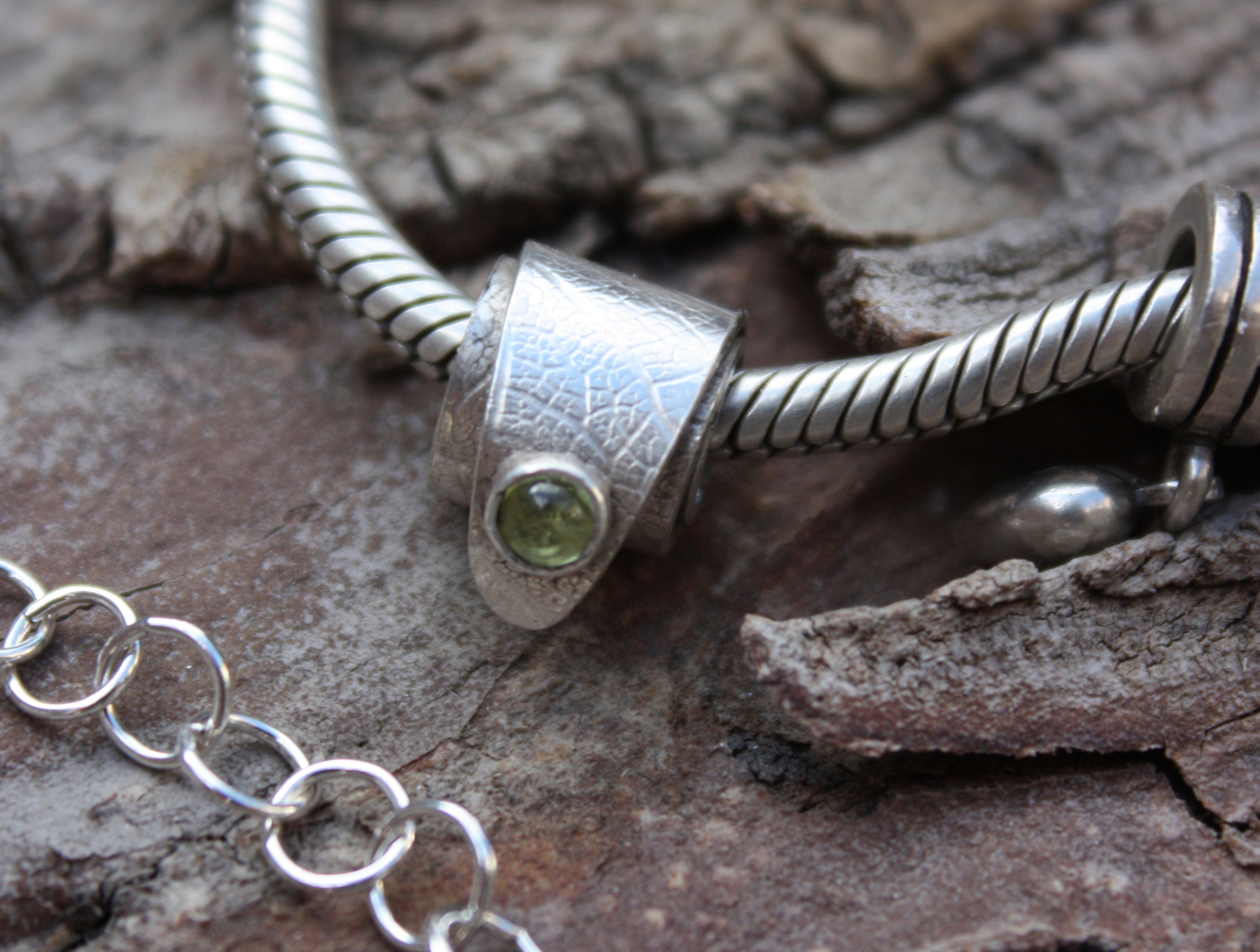 example silver charm with peridot stone set in silver